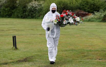 Un empleado de servicios funerarios durante un entierro en un cementerio londinense.