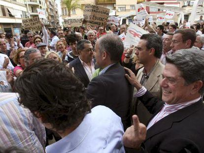 Federico Trillo, detrás de Francisco Camps, hace una peineta a la salida de un acto en Torrevieja.