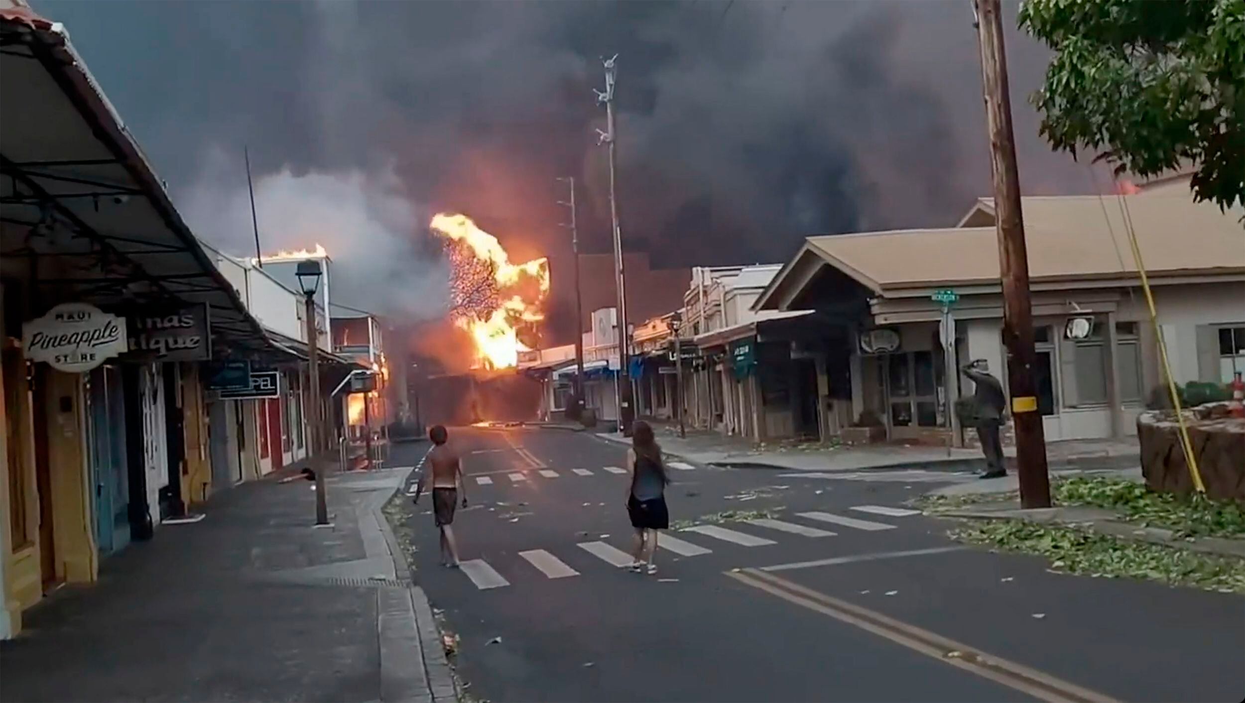 En la isla de Maui, visitada cada año por cientos de miles de turistas, las llamas han cerrado carreteras y escuelas y han obligado a movilizar a la Guardia Nacional para asistir en las tareas de rescate y lucha contra el fuego. En la imagen, fuego y llamas en una calle de Lahaina, el martes. 