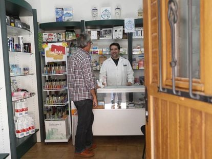 Francisco Aceituno atiende a un cliente en su farmacia de Villel de Mesa, Guadalajara el mi&eacute;rcoles pasado.
