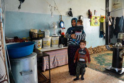 Qudna Fayad con el pequeño de sus niños en la habitación dentro del colegio abandonado donde vive con su marido y sus otros siete hijos.