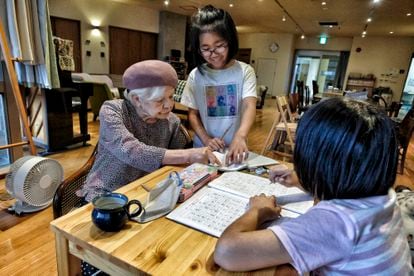 A sus 92 años, la exprofesora Kaneko ayuda con los deberes a dos niñas. 