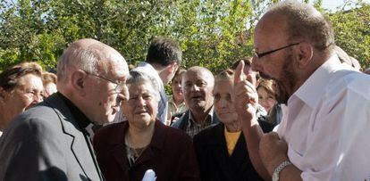 El vicario, a la izquierda, conversa con los vecinos de Piñor