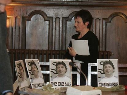 La alcaldesa de ANV, Inocencia Galparsoro, pasa por detrás de las fotos de Isaías Carrasco colocadas en las sillas vacías de los concejales socialistas.