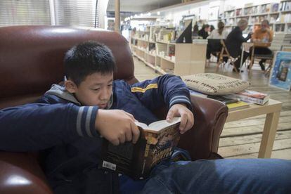 Hao Yu, de 12 anys, llegeix a la llibreria +Bernat, a Barcelona.