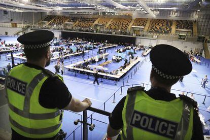 Agentes de la policía vigila en el estadio Emirates Arena en Glasgow el recuento de los votos en Escocia tras el cierre de los colegio electorales.