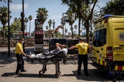 Dos sanitarios subían a un paciente a una ambulancia durante la ola de calor, en Barcelona, el lunes.