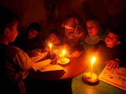 Un grupo de niñas y niños hacen sus deberes a la luz de unas velas en la Franja de Gaza, en una foto de archivo.
