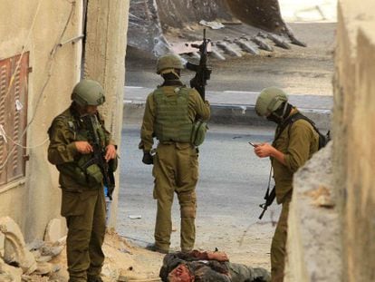 Soldados israelíes, junto al cadáver de uno de los dos palestinos. / Foto: AFP | Vídeo: Reuters