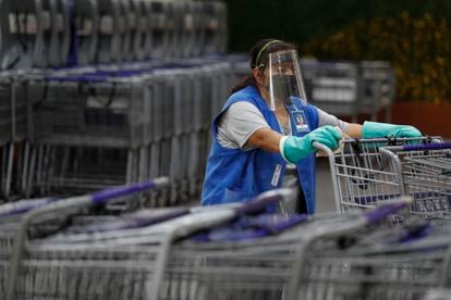 Una mujer desinfecta los carritos del supermercado en Ciudad de México, el 15 de junio.