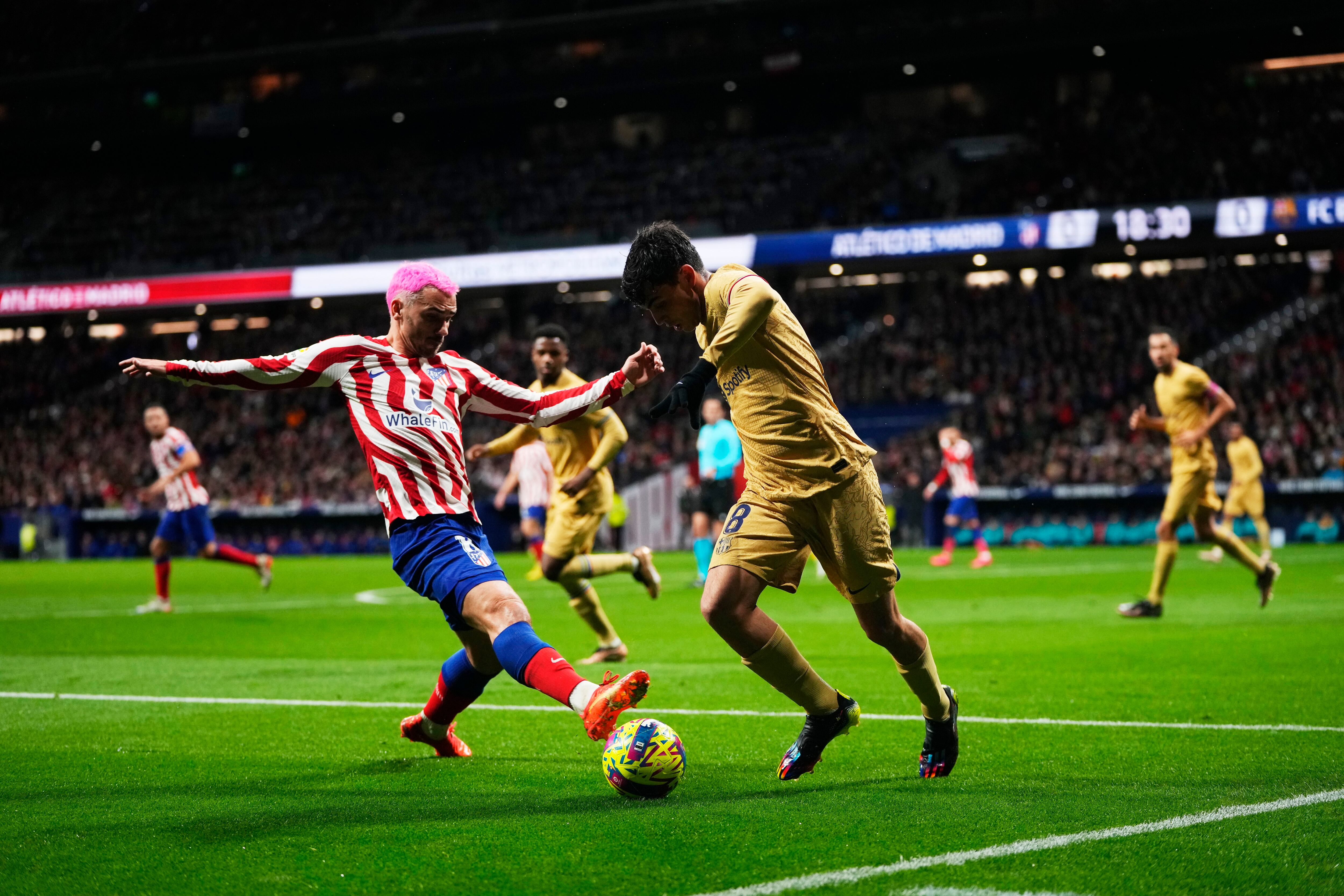 Pedri se lleva el balón ante Griezmann.