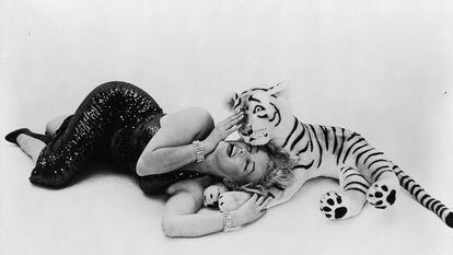 La estrella de cine estadounidense Marilyn Monroe juega con un tigre de peluche, en 1957.