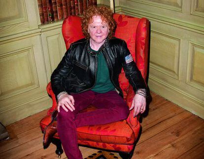 Mick Hucknall, su pelo rojo, sus pantalones rojos y su silla roja posan para ICON en Londres.