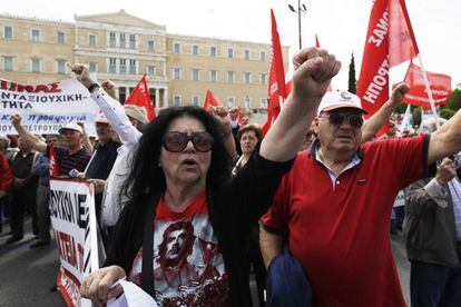 Un grupo de manifestantes alzan sus puños mientras cantan la Internacional en una concentración frente al parlamento griego, en Atenas.

