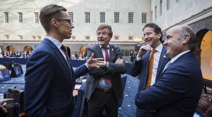 El ministro de Econom&iacute;a, Luis de Guindos, y el presidente del Eurogrupo, Jeroen Dijsselbloem, charlan con el ministro belga de Finanzas, John Robert Overtveldt, y el ministro finland&eacute;s de Finanzas, Alexander Stubb