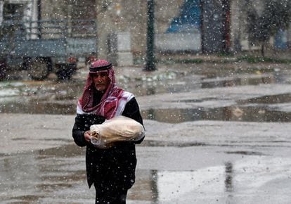 Un hombre con un pan en sus brazos en la ciudad siria de Al Qusayr.