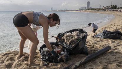 Una trabajadora de la hosteler&iacute;a recogiendo basura en la Mar Bella