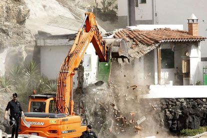 Una excavadora derriba una de las nueve casas del poblado pesquero de Cho Vito.