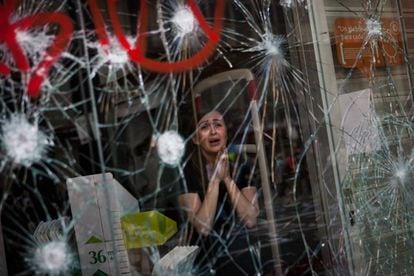Dependienta aterrorizada ante los destrozos en su local durante la huelga general del 29 de marzo de 2012.