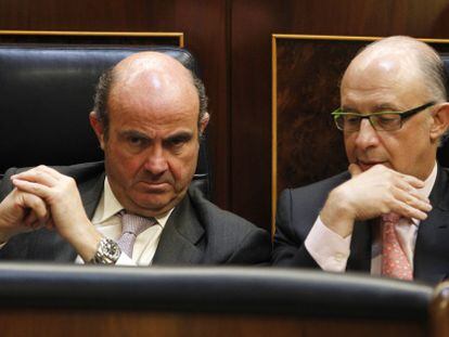 El ministro de Econom&iacute;a, Luis de Guindos (izquierda), escucha al responsable de Hacienda, Crist&oacute;bal Montoro. 