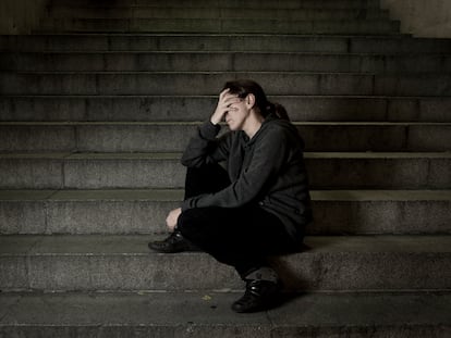 Una mujer sentada sola en unas escaleras.