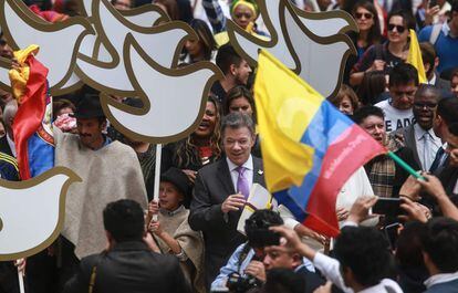 El presidente colombiano, Juan Manuel Santos (c), lleva una copia del texto final del acuerdo de paz con las Fuerzas Armadas Revolucionarias de Colombia (FARC), en su camino al Congreso Nacional de Colombia, en Bogotá.