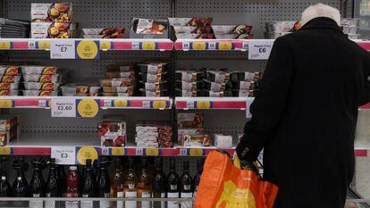 Un hombre hace la compra en un supermercado Tesco, en Inglaterra.