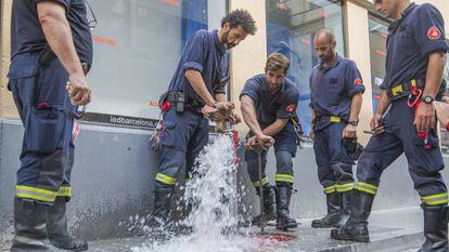 Bomberos comprueban una boca de incendios en Gracia.