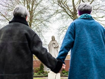 Dos mujeres se dan la mano hoy frente a una imagen de la Virgen María en el el convento de Lüdinghausen, (Alemania).