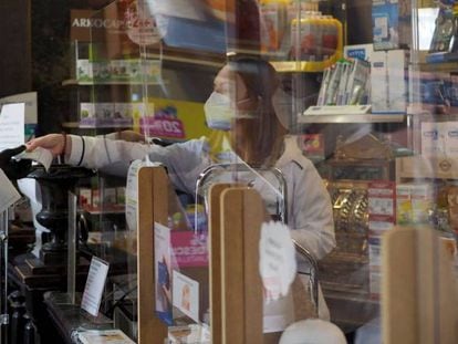 Una persona es atendida por una trabajadora de una farmacia de Vitoria durante el estado de alarma por la crisis del Covid-19