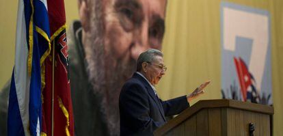 Ra&uacute;l Castro, durante el congreso comunista, custodiado por una foto de su hermano Fidel.