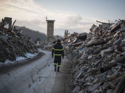 Un bombero camina por lo que un d&iacute;a fue la calle principal de Amatrice.