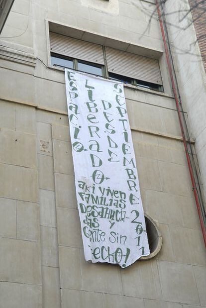 La pancarta que cuelga de una de las ventanas de las viviendas sobre el Albéniz.