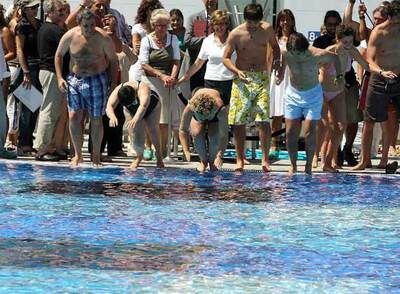 Participantes en el acto lanzándose a la piscina, ayer, en el DIR de la calle de Ganduxer, en Barcelona.