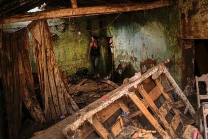 Una mujer entra a su casa destruida por una inundación en la comunidad Las Tejerías, en Venezuela, el 10 de octubre.