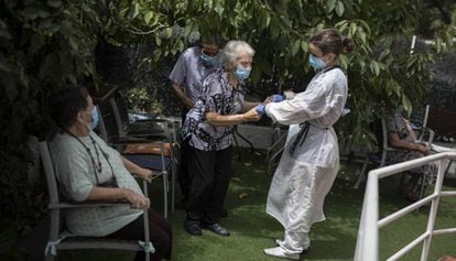 Una cuidadora atén una dona gran a la residència geriàtrica Gravi, a Polinyà.