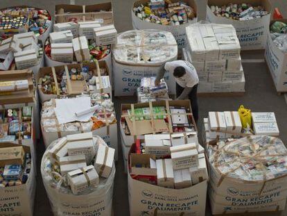 Un voluntario ordena los contenedores de cartón en el almacén del Banco de los Alimentos, en Barcelona.