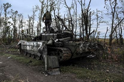 Un soldado ucranio de pie sobre un tanque ruso abandonado cerca de una aldea a las afueras de Izium, región de Járkov (Ucrania), el domingo.