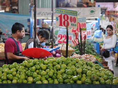 Un vendedor de frutas y verduras atiende en su puesto en un mercado en Ciudad de México.