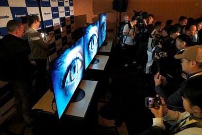 Journalists look at Panasonic Z95A and Z93A OLED TVs with built-in Fire TV during Panasonic's CES 2024 press conference.