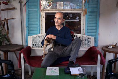 Rayek R. Rizek posa en Neve Shalom-Wahat as Salam, en su café ante el libro sobre el pueblo del que es autor "El oso hormiguero y el jaguar", el 5 de diciembre de 2023. 