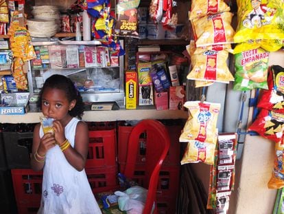 Una niña consume una bebida azucarada dentro de un negocio en Medellín, Colombia.