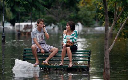 Dos vecinos esperan en una plaza de Buenos Aires durante las inundaciones de 2013.