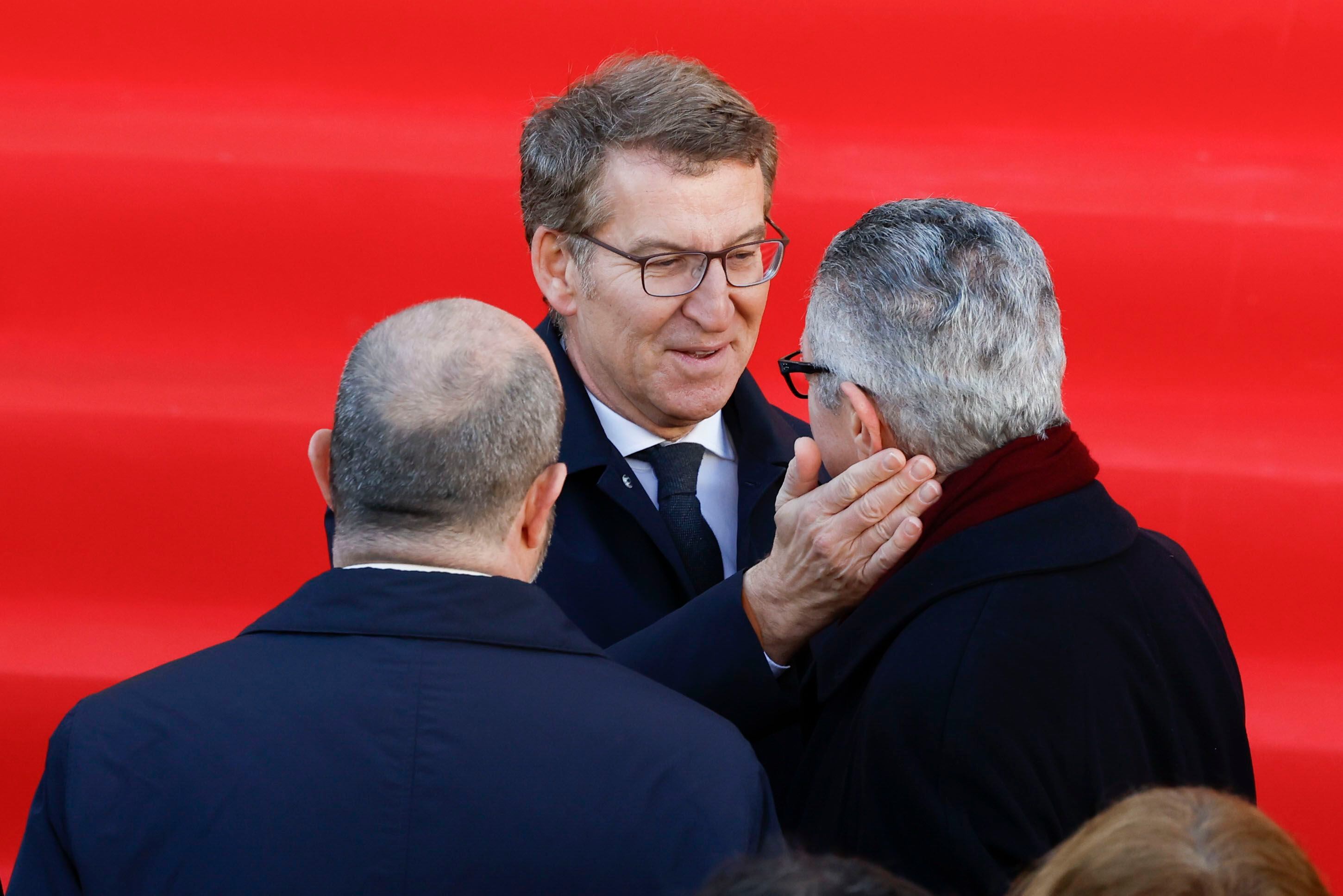 El presidente del PP, Alberto Núñez Feijóo (centro), saluda al exalcalde de Madrid Alberto Ruiz Gallardón, durante el acto en memoria de las víctimas de los atentados del 11-M celebrado este lunes en la Puerta del Sol. 