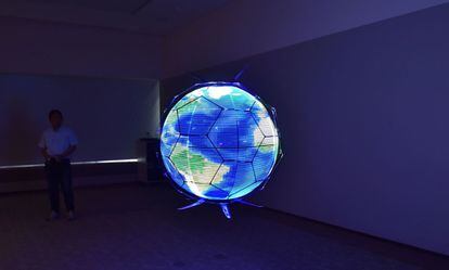 Un miembro de NTT DOCOMO realiza una demostración de un vehículo aéreo no tripulado que muestra imágenes LED en una pantalla esférica omnidireccional mientras se encuentra en vuelo, en los laboratorios de investigación de la compañía, en Yokosuka (Japón).