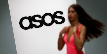 FILE PHOTO: A model walks on an in-house catwalk at the ASOS headquarters in London