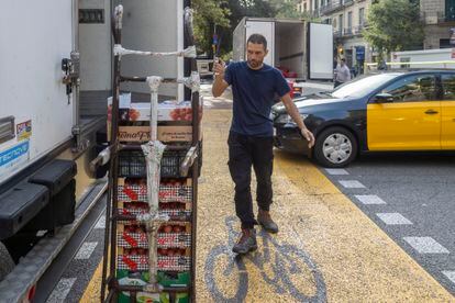 Repartidores en el Eixample de Barcelona. En la imagen, Álex, junto a la camioneta con la que entrega fruta y verdura.