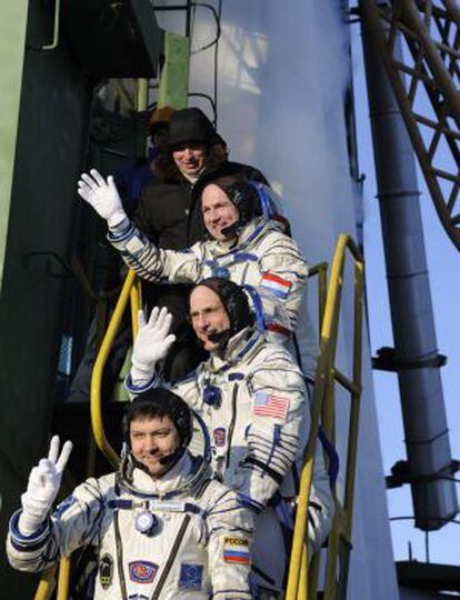 Los astronautas André Kuipers, Don Pettit y Oleg Kononenko, de arriba a abajo, listos para entrar en el cohete Soyuz.