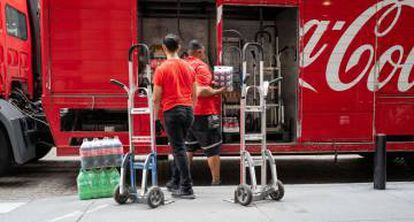 Unos trabajadores cargan un camión de Coca-Cola.