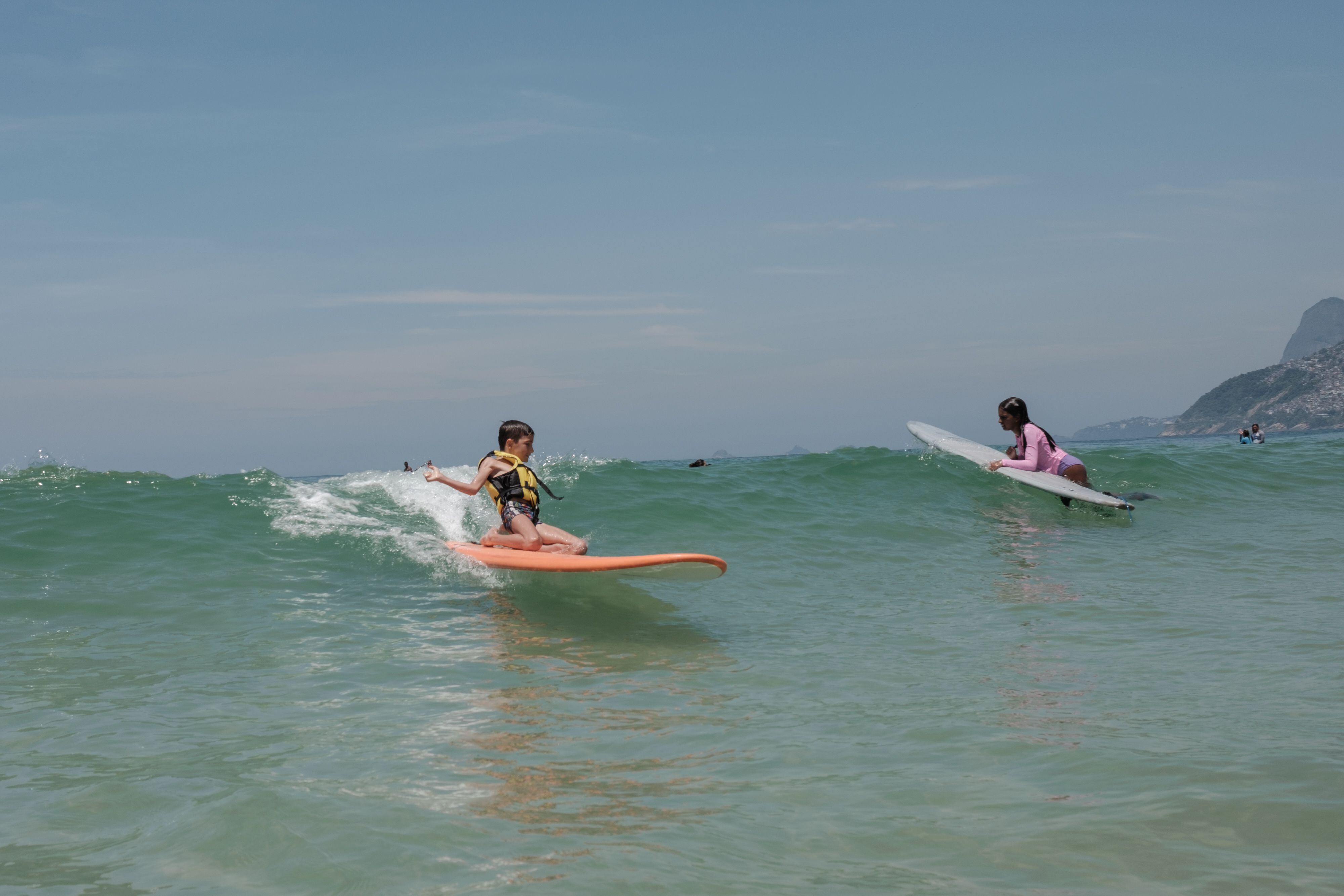 Luca, uno de los alumnos del proyecto Ondas Arpoador, surfea una ola durante una de las clases en la playa de Ipanema.